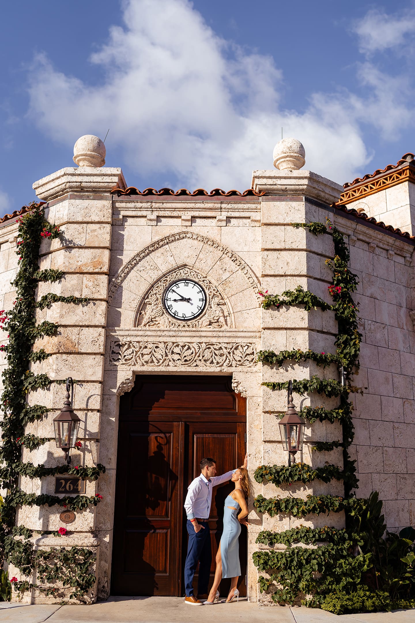 Couple embracing at sunrise by the Palm Beach clock tower, capturing golden hour glow