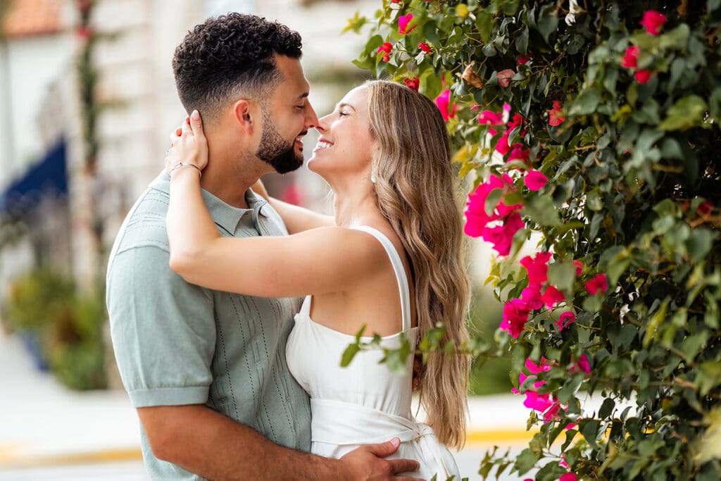 Engaged couple kissing under ivy-covered arches on Worth Avenue in Palm Beach