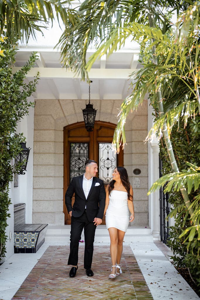 Couple walking near historic architecture in Palm Beach during engagement session