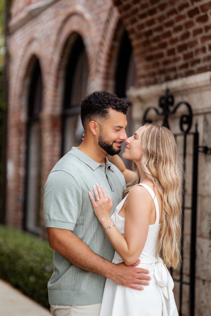 Engaged couple embracing on Worth Avenue in Palm Beach with soft sunrise hour light