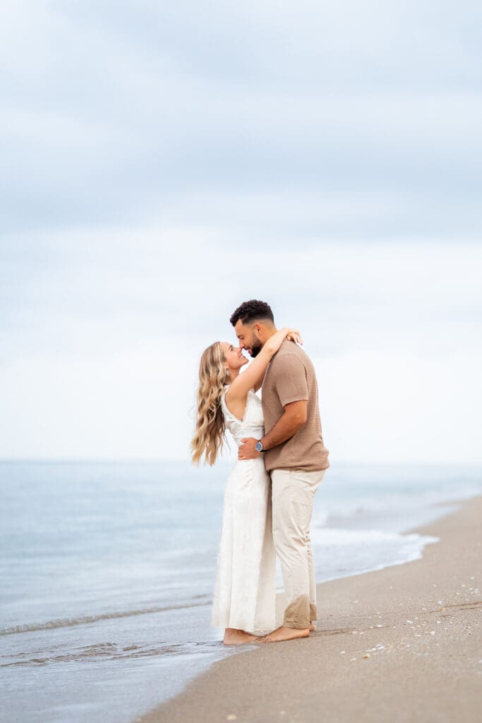 Couple embracing on the beach for a sunrise engagement shoot